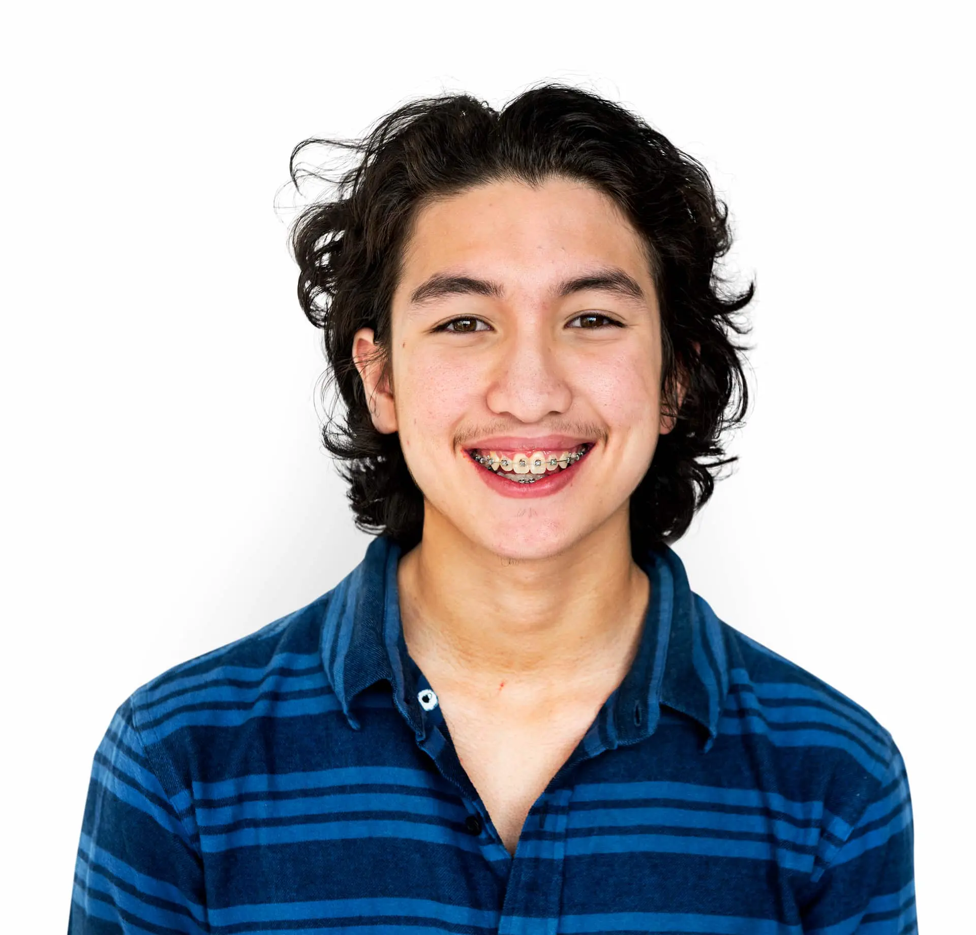 An adult braces with long hair, wearing a blue striped shirt, smiles warmly against a plain white background in Suwanee or Tucker, GA