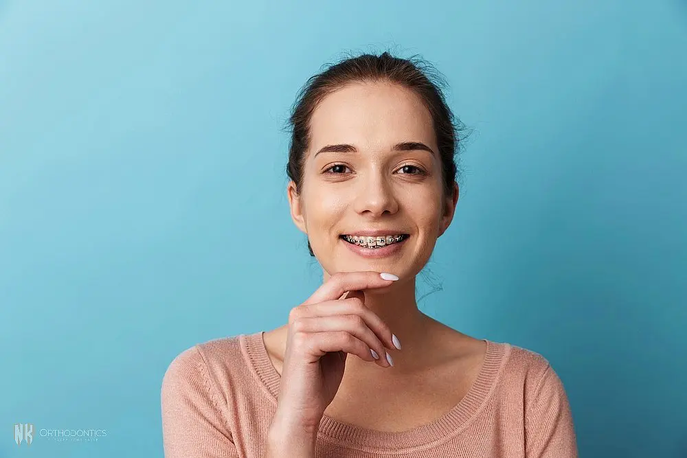 a woman with metal braces posing at the camera after understanding about how long do braces take in suwanee and tucker, ga
