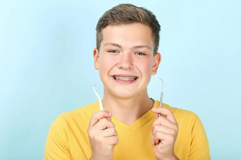 young man with metal braces toothbrush dentist tool - How to Floss with Braces in Suwanee and Tucker, GA