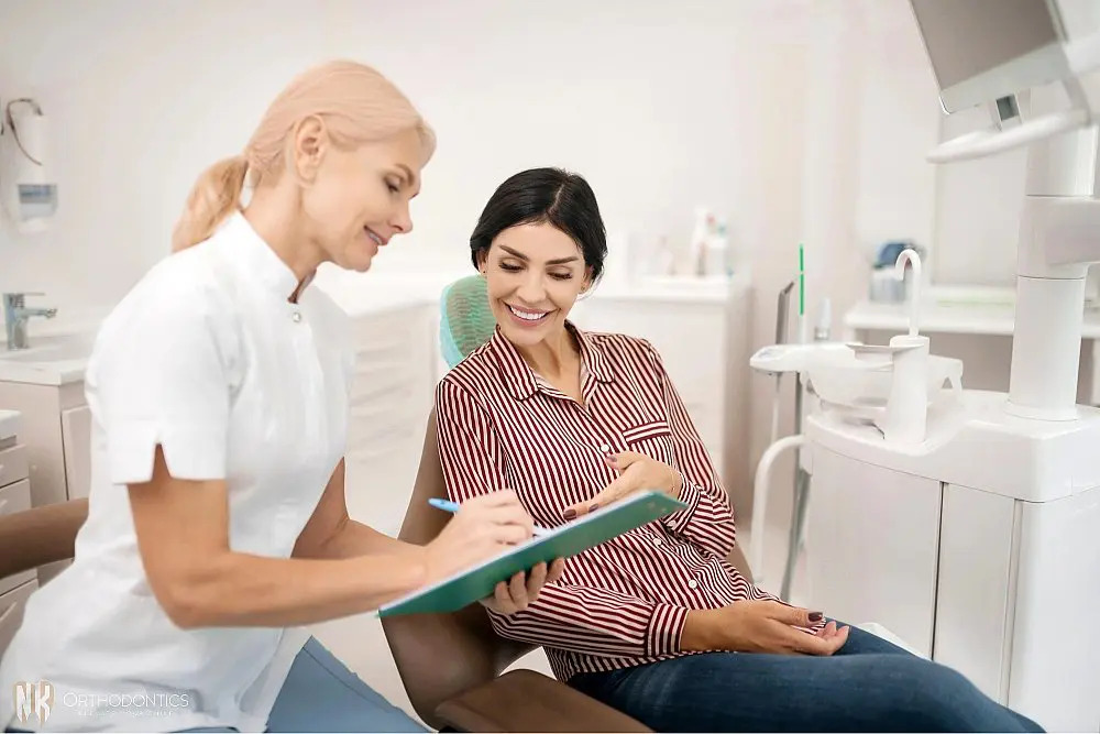 patient telling her orthodontist information about herself - TMJ Treatment in Suwanee and Tucker, GA 